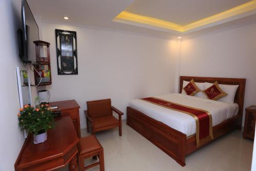 a bedroom with a bed and a desk and a television at SONG ANH HOTEL in Can Tho