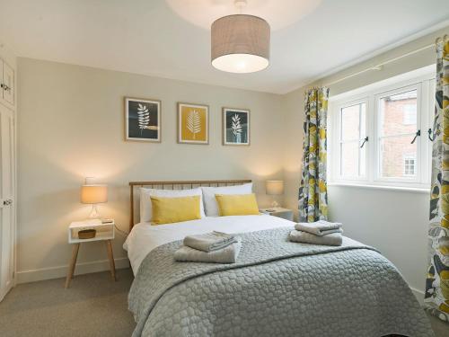 a bedroom with a large bed with yellow pillows at Meadow View in Swafield