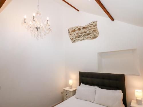 a bedroom with a bed and a chandelier at Beach Road House in Ilfracombe
