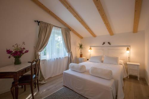 a bedroom with a bed and a table and a window at 9b-The Resort in Sežana