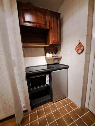 a small kitchen with a stove and cabinets at MEADOWS Apartment in Ponte di Legno