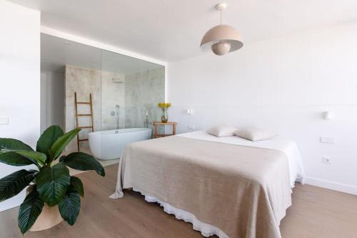ein weißes Schlafzimmer mit einem Bett und einer Badewanne in der Unterkunft Diamond Suite Bajamar in Bajamar