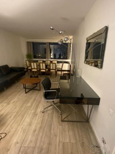 - un salon avec un bureau, une table et des chaises dans l'établissement Tour Défense 2000 Magnifique Appartement, à Puteaux
