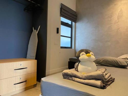 einem ausgestopften Pinguin auf einem Bett im Schlafzimmer in der Unterkunft 2R1B 5Pax Union Executive Suites Bandar Sunway in Petaling Jaya