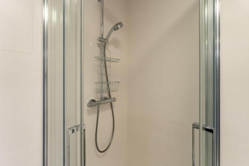 a shower with a shower head on a wall at Beachmee Condo Rogowo in Rogowo