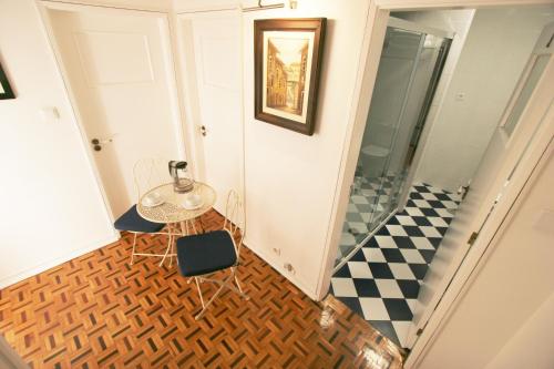 a hallway with a table and a checkered floor at Oleiros Rooms City Center in Coimbra