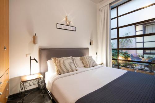 a bedroom with a large bed and a large window at Villa Meliti in Athens