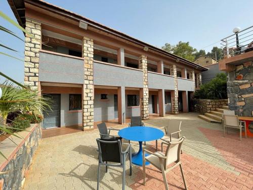 a patio with a table and chairs in front of a building at Hôtel les truites in Imouzzer Kandar