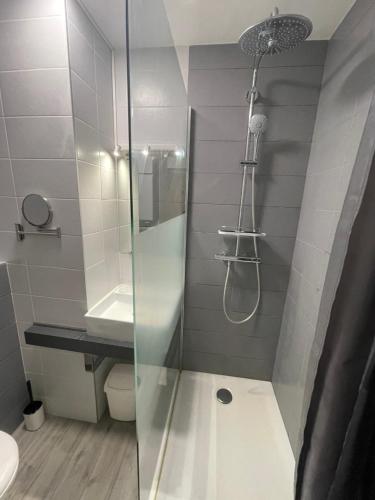 La salle de bains est pourvue d'une douche avec une porte en verre. dans l'établissement Superbe studio, terrasse, piscine, parking, au Grau-du-Roi