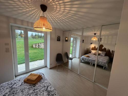 - une chambre avec un lit et un grand mur en verre dans l'établissement Country house with swimming pool Le Moulinas, à Saint-Salvadou