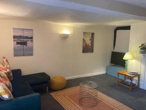 uma sala de estar com um sofá e uma televisão em Charming holiday apartment in central Woodbridge em Woodbridge