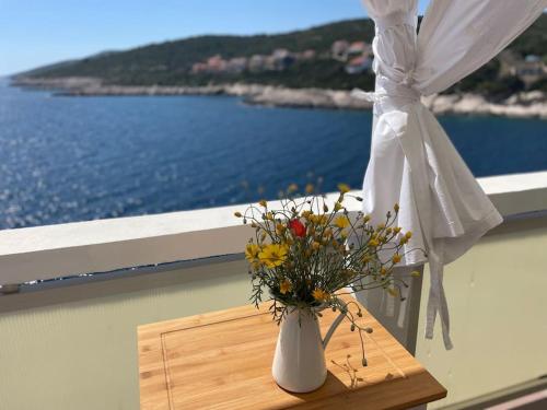 a vase of flowers sitting on a table next to a window at SEAWAY in Zavalatica