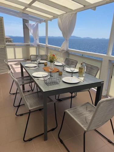 a table and chairs on a balcony with a view of the ocean at SEAWAY in Zavalatica