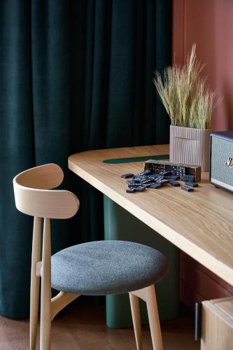 a wooden table with a chair next to a desk at Verno House Budapest, Vignette Collection by IHG in Budapest