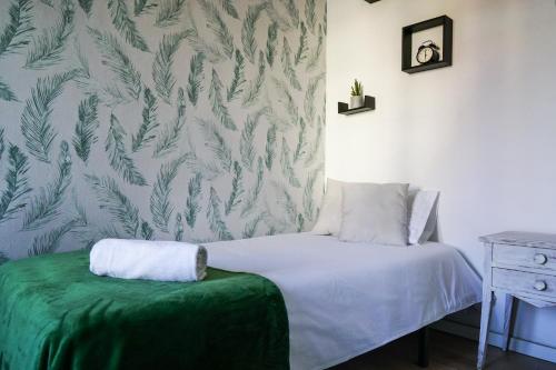 a small bedroom with a bed with a green blanket at Ruzafa Apartment in Valencia