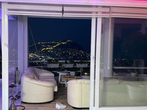 a balcony with a view of a city at night at Alanya Bektaslar 3+1 lüks daire in Alanya