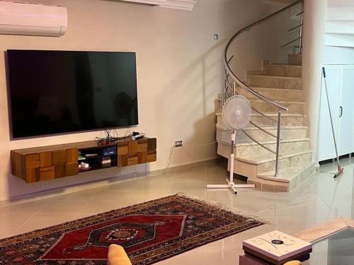 a living room with a flat screen tv and stairs at Alanya Bektaslar 3+1 lüks daire in Alanya