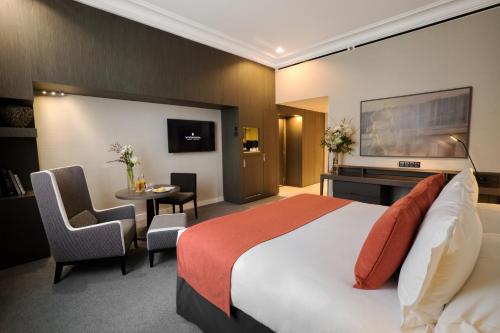 a hotel room with a bed and a table and chairs at InterContinental Marseille - Hotel Dieu, an IHG Hotel in Marseille