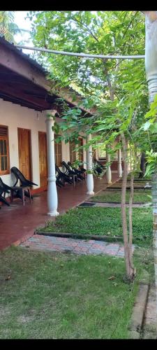 einen Innenhof mit Stühlen und einem Baum in einem Gebäude in der Unterkunft Hotel Sea Shadow in Trincomalee