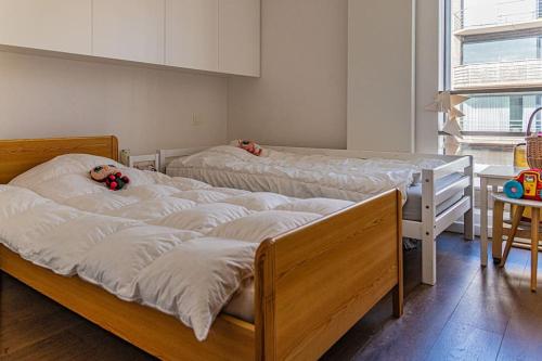 two beds with teddy bears on them in a room at Prachtig & ruim luxe appartement in Bruges