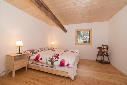 1 dormitorio con cama y techo de madera en La Grobla - Die ruhige & heimelige Ferienwohnung en Zillis