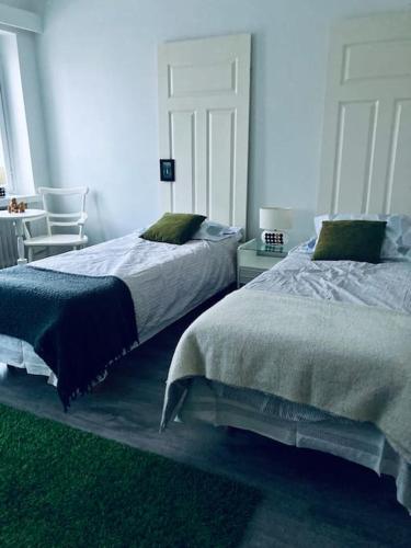 a bedroom with two beds and a table and chairs at Viehättävä asunto Heinolan keskustassa in Heinola