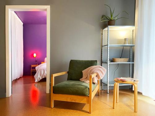 デュースブルクにあるnew design apartmentの紫の壁の客室で、緑の椅子が備わります。