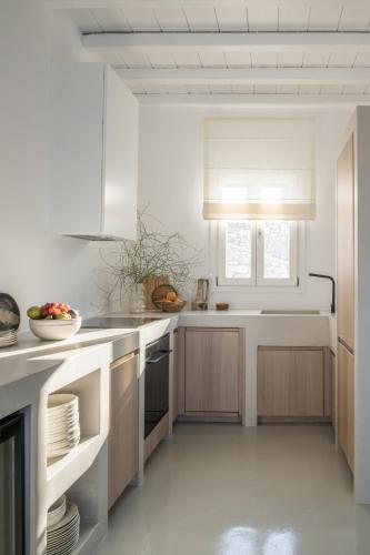 a white kitchen with a sink and a stove at Mykonos Esti Luxury Villas in Agios Ioannis Mykonos