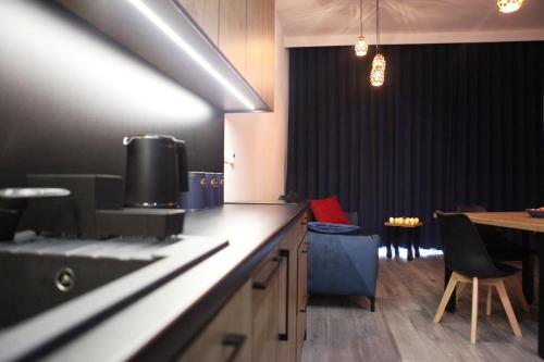 a kitchen with a counter and a table and a dining room at Apartament Szafirowy in Zarzecze