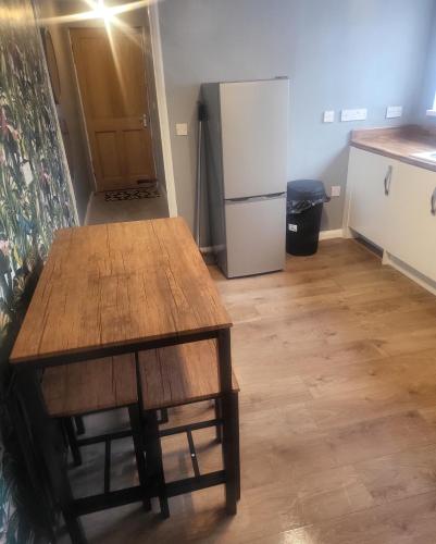 a kitchen with a wooden table and a refrigerator at Dundas Apartments - Furnished Short Lets in Sunderland