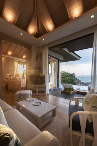 a living room with a couch and a table at Cape Fahn Hotel - Private Islands Samui in Choeng Mon Beach