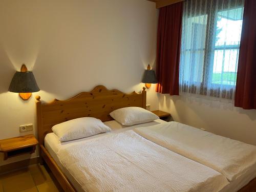 een slaapkamer met een groot bed met 2 kussens bij FAMILIENAPPARTMENT MIT GARTEN - Gerlitzen in Deutschberg