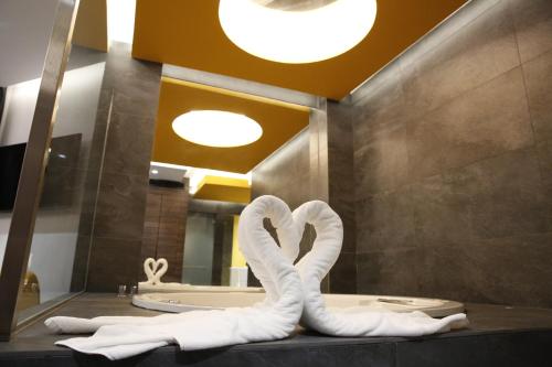 a bathroom with two swans made out of towels at Hotel Luve in San Antonio de Benagéber