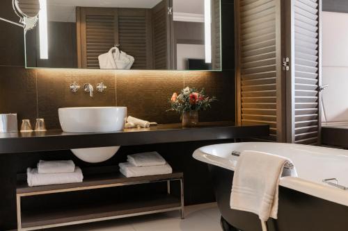 a bathroom with a tub and a sink and a bath tub at InterContinental Marseille - Hotel Dieu by IHG in Marseille