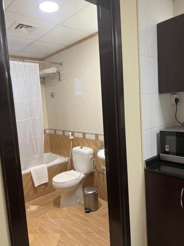 a bathroom with a toilet and a bath tub at Studio Deira naif in Dubai
