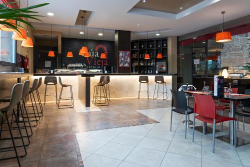 a bar in a restaurant with red chairs and tables at F&G Logroño in Logroño