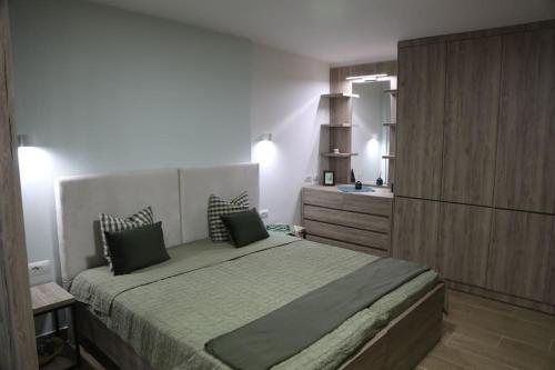 a bedroom with a large bed and a dresser at Kosta's Home in Tirana