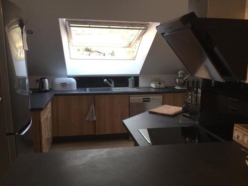 une cuisine avec un évier et une fenêtre dans l'établissement Centre superbe appt 6 personnes avec terrasse classé 3 étoiles, à La Bresse