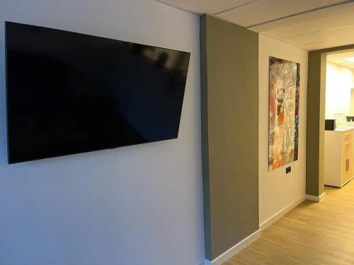 Elle comprend une télévision à écran plat suspendue au mur. dans l'établissement Exklusive Ferienwohnung in Osterburg, à Osterburg Siedlung