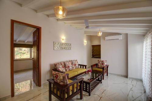 a living room with a couch and a table and chairs at Antalya Villa - 5BHK with Private Pool, Baga in Baga