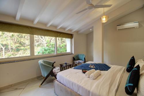 a bedroom with a bed with two towels on it at Antalya Villa - 5BHK with Private Pool, Baga in Baga