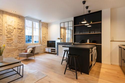 une cuisine avec un bar et un salon dans l'établissement Le Merveilleux de Godron, à Nancy