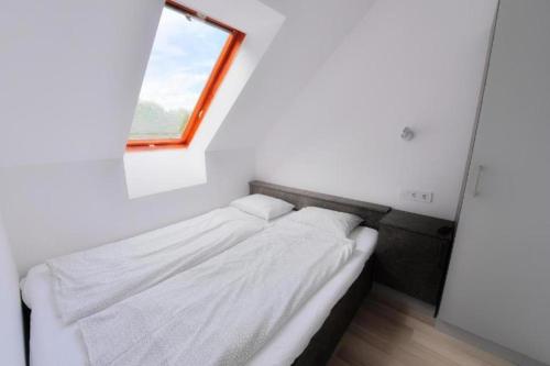 Dormitorio pequeño con cama y ventana en Villa Oliver Balatonlelle en Balatonlelle