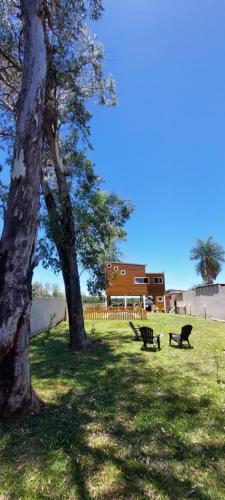 a park with two benches and a tree at LA CASITA DE CANDELARIA in Garupá