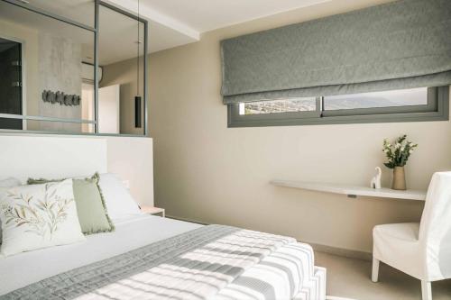 a bedroom with a bed and a window and a chair at Villa Sorian Kokkino in Vlachata