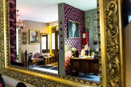 Eine Frau, die an einem Tisch im Spiegel sitzt. in der Unterkunft Villa Cuprum in Lubin