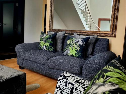 a blue couch in a living room with a mirror at Hartbeespoort Lifestyle Guest House in Hartbeespoort