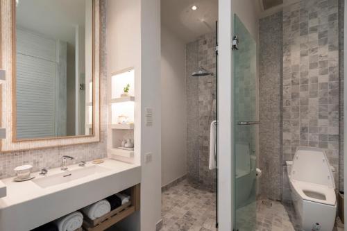 a bathroom with a sink and a toilet and a shower at Cape Fahn Hotel - Private Islands Samui in Choeng Mon Beach
