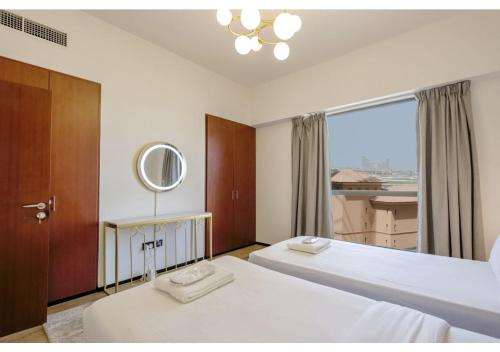 a bedroom with two beds and a large window at JBR The Walk Sadaf Suites - Fully Upgraded By Livbnb in Dubai