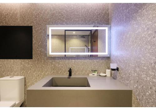 a bathroom with a sink and a mirror and a toilet at JBR The Walk Sadaf Suites - Fully Upgraded By Livbnb in Dubai